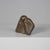 An expressive bronze sculpture depicting a crouching male figure in a compact, introspective pose. The body is reduced to...
