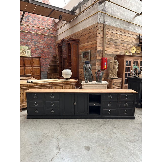 Handcrafted sideboard. It features 12 drawers with label holders, 2 doors opening onto a shelf, and 2 open compartments....