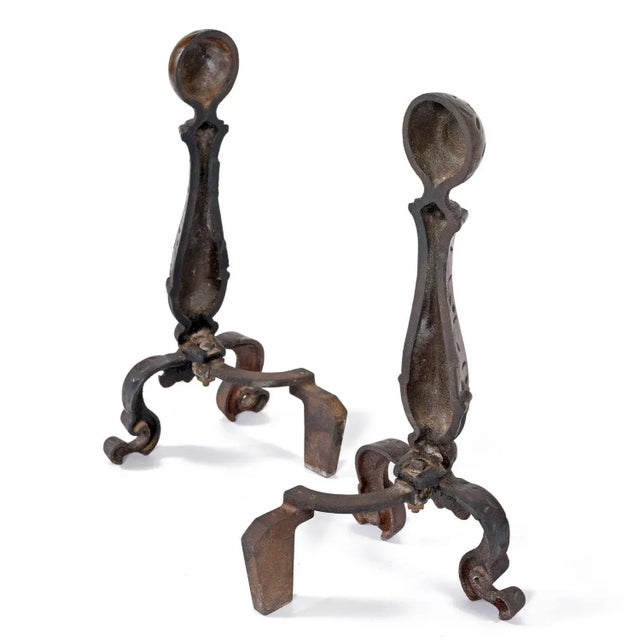 Handsome pair of mid-20th Century hammered texture andirons. The andirons are in traditional form with the hourglass body...