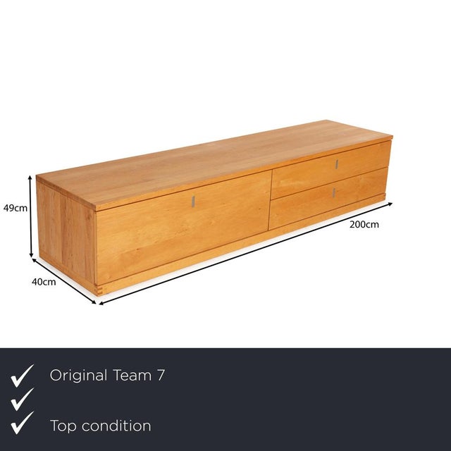 The Cubus sideboard by Team 7 is made of light brown wood and stands floor-to-ceiling. It features a minimalist, linear...