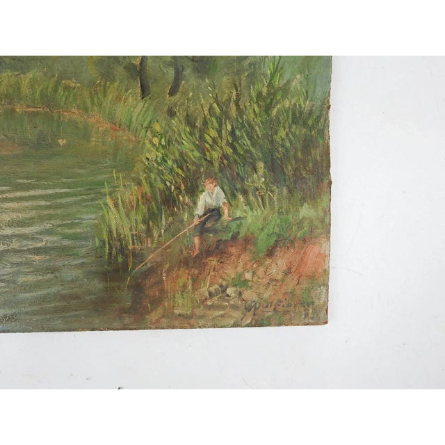 Vintage mid 20th century French oil on masonite riverside landscape with village and fisherman. Signed illegibly lower...
