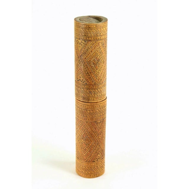 A fine old ethnographic relic from Indonesia It is a cylindrical lime container made of carved wood, most likely bamboo...