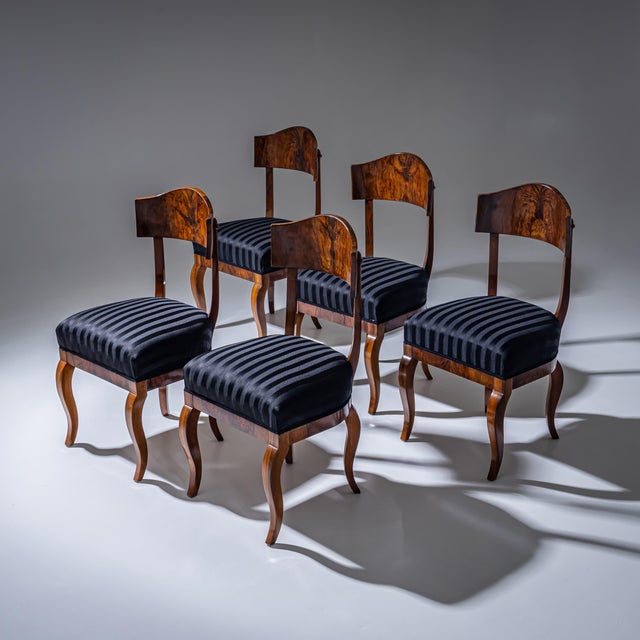 Set of five Biedermeier shovel-back chairs featuring broad, rounded backrests and gently S-shaped legs. The chairs are...