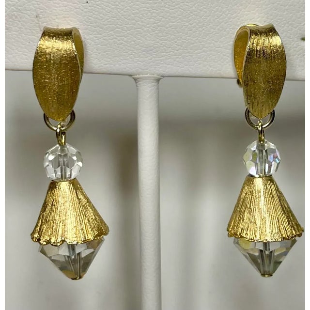 This is part of Chairish’s Costume Jewelry assortment. Bright gold clip on earrings with Aurora borealis crystal drop...