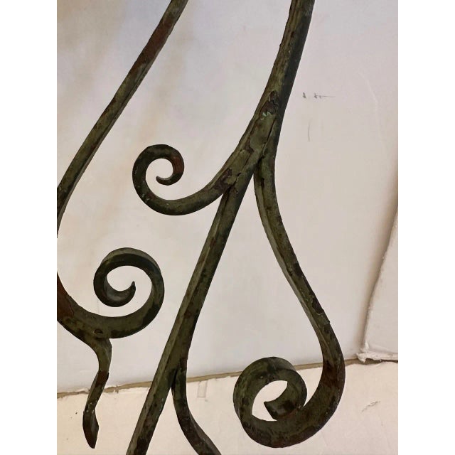 Pair of antique custom aged wrought iron wall sconces having lovely curlicues and shades. Sconces 35.5” H to top of shade...