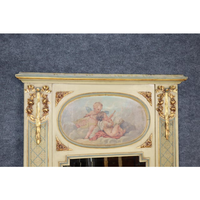This highly decorative Louis XVI-style trumeau mirror presents an elegant combination of painted decoration, parcel-gilt...