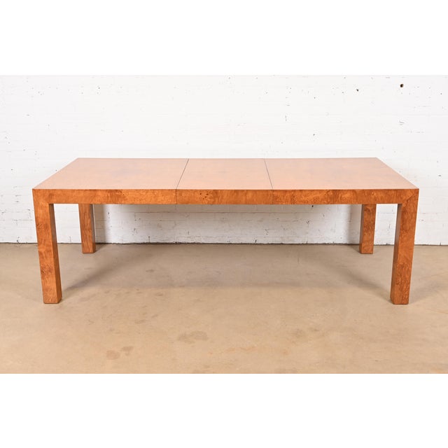 An exceptional Mid-Century Modern Parsons extension dining table in gorgeous book-matched burled olive wood By Milo...