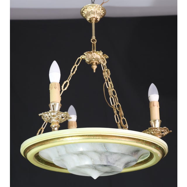 A beautiful alabaster chandelier from the last century. The chandelier consists of an alabaster disc supported by a...