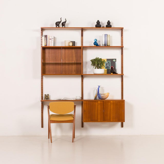 This teak wall unit with a desk-shelf was designed by poul cadovius for cado in the 1960s. Its simple form provides...