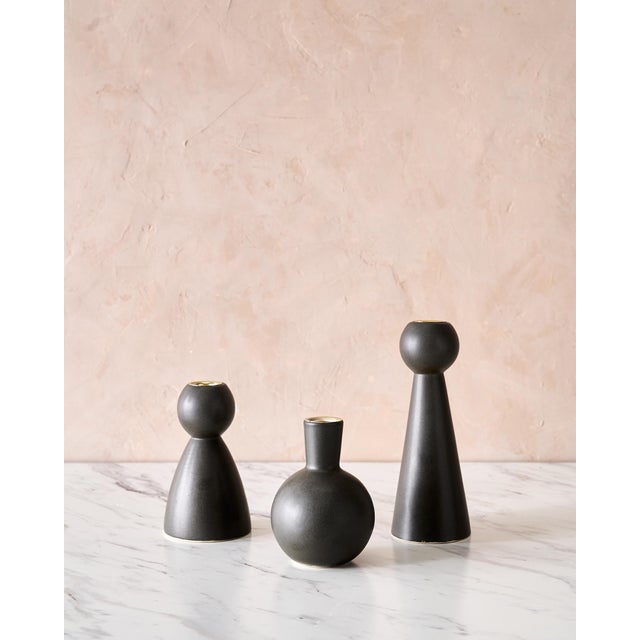 A sculptural trio of handmade ceramic candle holders by Lostine, featuring the brand's sought-after Bella, Beau, and Bobbi...