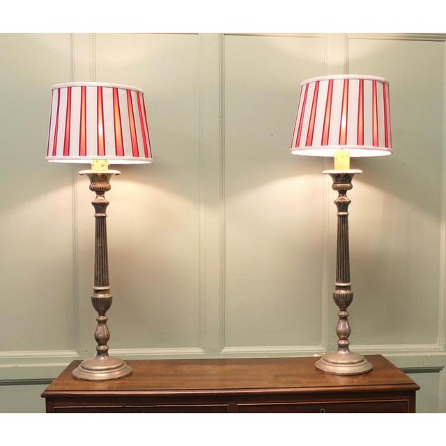 These lamps are statuesque pieces, silver-plated with a very large sculptured central column, the lamps have been matched...