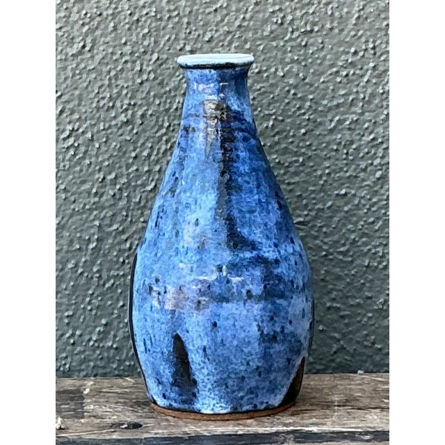 Crafted with expressive artisan technique, this vintage studio pottery vase features a tapered bottle silhouette with a...