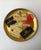 A round cocktail serving tray with gold leaf and decoupage collage of champagne and spirits labels, circa mid‑20th...