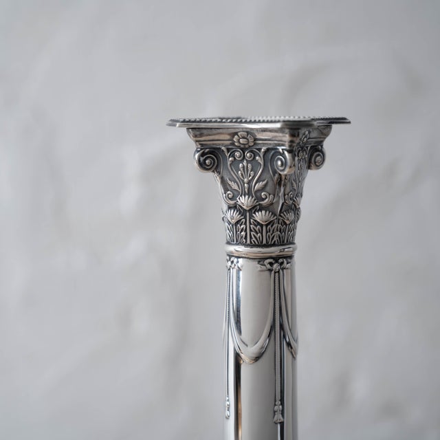 A pair of classic neoclassical candlesticks by Hawksworth, Eyre & Co Ltd, featuring finely chased Corinthian-style...
