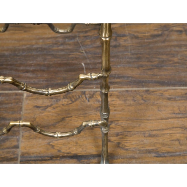 A French brass faux bamboo wine rack from the mid 20th century with arching side supports and pad feet. This charming...