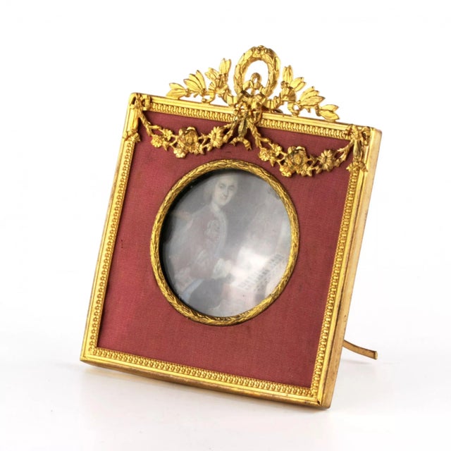 Antique photo frame of the late 19th century. The wooden case, covered with fabric, is framed with a classic frame, gilded...