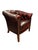 Classic Chesterfield-style club chair upholstered in deep oxblood red leatherette with rich patina and deep button-...