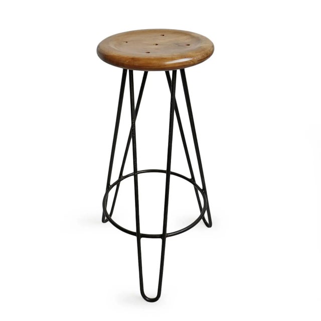 Simple teak wood frisbee top bar stool with industrial style iron base. Each varies slightly in natural wood tones/grain.