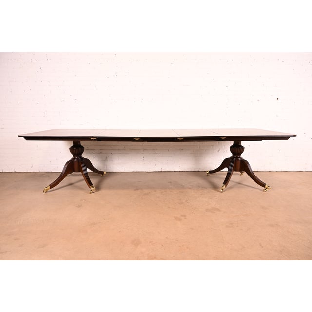 An exceptional antique Georgian or Regency style double pedestal extension dining table In the manner of Baker Furniture...