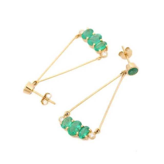This is part of Chairish’s Fine Jewelry assortment. Stylish Emerald Diamond Dangle Earrings in 18K gold to make a...