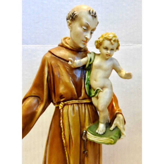Saint Anthony is holding a cherubic child on his book and is looking at him lovingly. The porcelain has been glazed in...