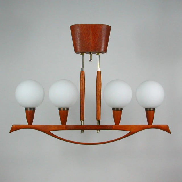 This beautiful vintage four-light chandelier was manufactured in sweden in the 1960s. It is made of brass and teak and has...