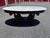 An elegant vintage Victorian Revival center table featuring a substantial oval white marble top resting on an ornately...