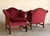 A handsome pair of Chippendale-style club chairs with a graceful camelback silhouette and generously scrolled, rolled...