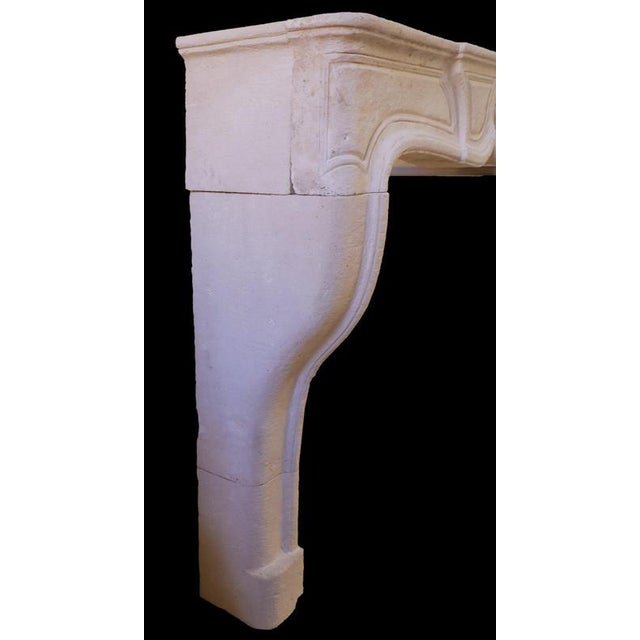 Elegantly understated yet classically inspired, this 20th-century French Louis XV-style limestone fireplace features soft...