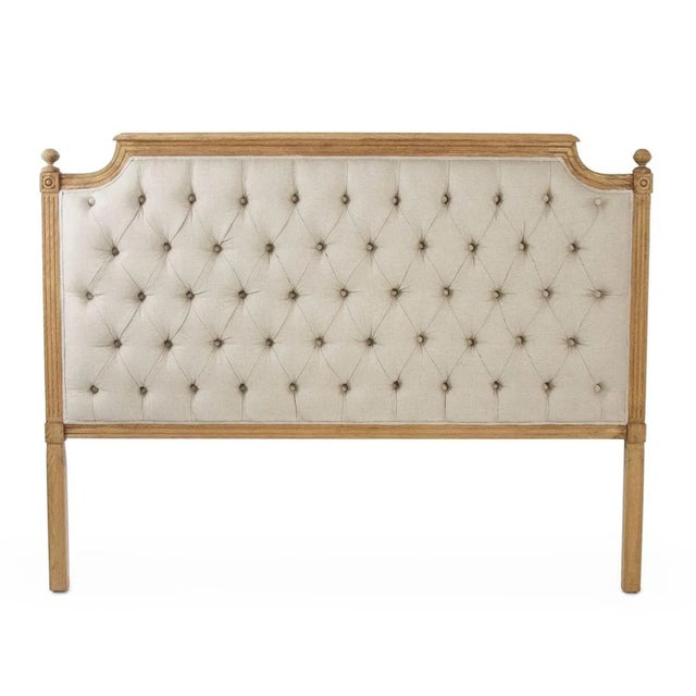 Tufted queen headboard upholstered in natural linen on natural oak.