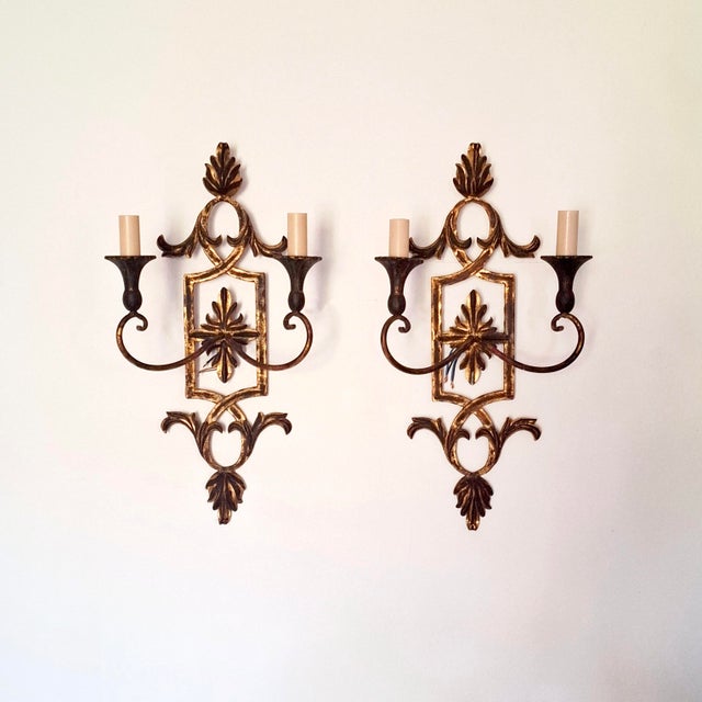 Set of two wall lights made of gilded wrought iron and wood, by the Italian company Palladio, manufactured in the 1970s....