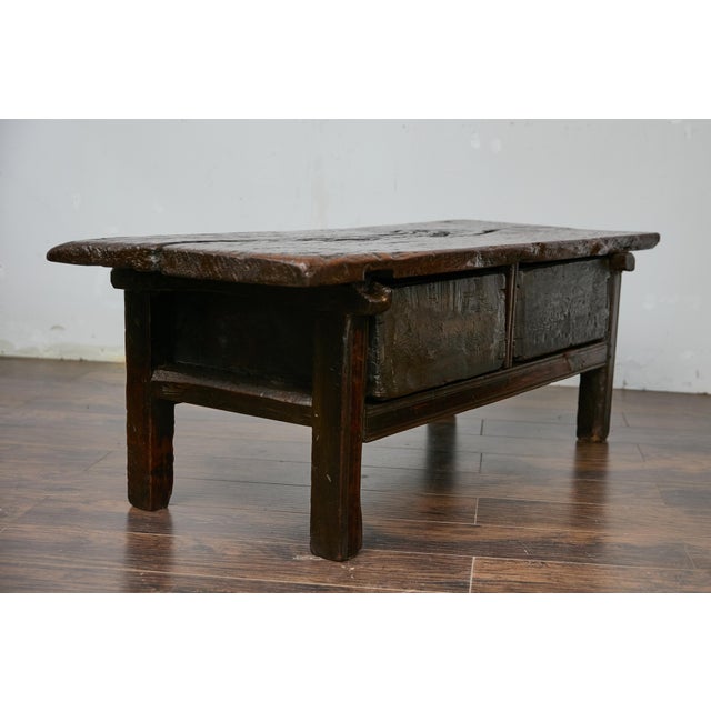 A Spanish oak coffee table from the early 19th century with two drawers and carved décor. This antique Spanish oak table,...