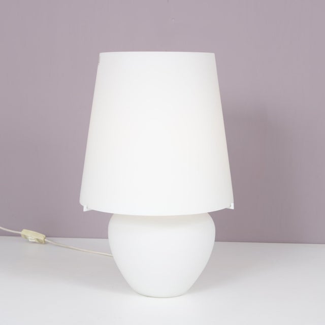 1990s white glass table lamp by Punto Luce, Murano, Italy. A refined example of Italian glass lighting design, crafted in...