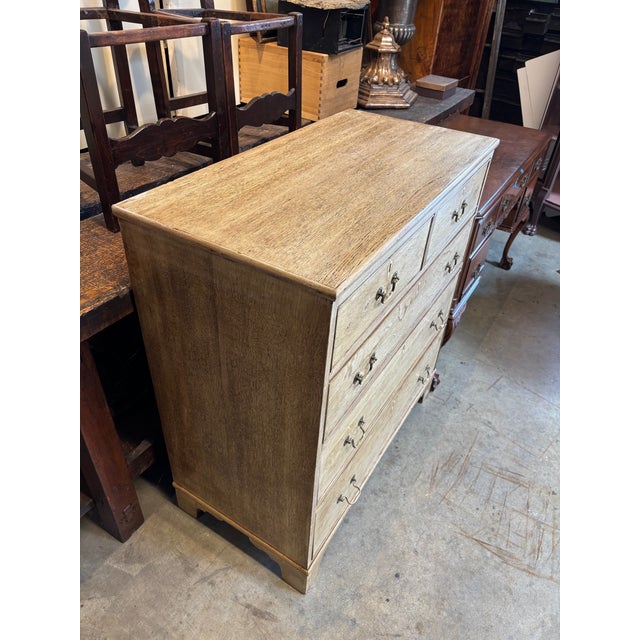 A "two-over-three" arrangement (two small drawers over three full-width drawers). Material: It features a bleached or...