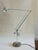 Fully articulated task lamp in polished chrome with acrylic counterweight system and transparent disc base. The scissor-...