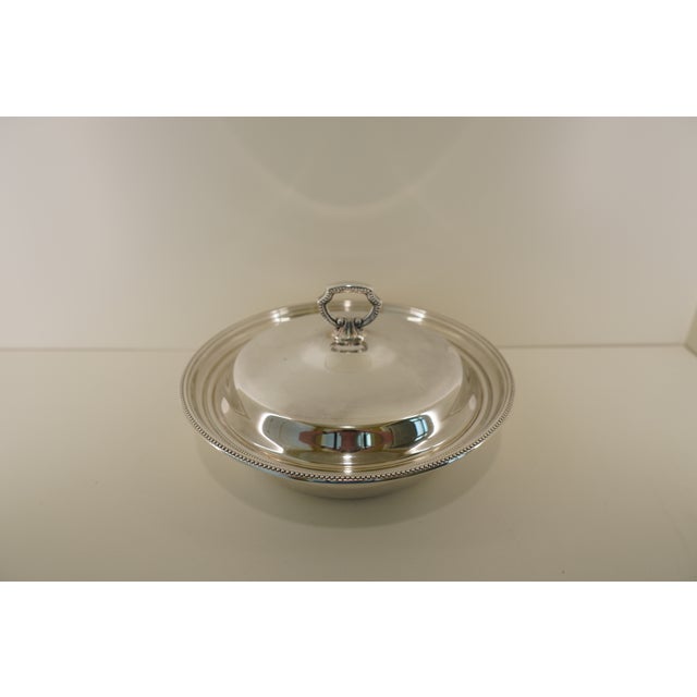 This vintage Towle silverplate serving dish presents a timeless and refined tableware design, featuring a gently domed lid...
