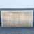 A striking vintage postmodern credenza featuring a warm faux travertine laminate finish with softly rounded corners and...