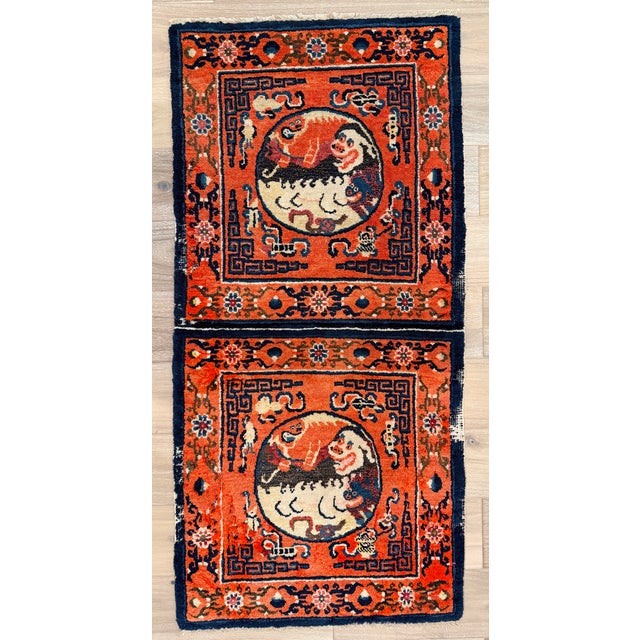 Hand-knotted wool rug measuring 2'3" x 4'7" (27" x 55"), featuring two stacked roundels with stylized guardian lion motifs...