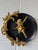 A striking pair of vintage Hollywood Regency wall plaques featuring sculptural gilt-metal cherubs against glossy black...