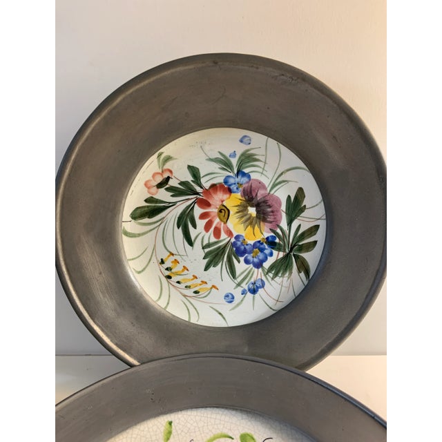 Wonderful set of 2 hand-painted vintage plates with pewter metal rims for hanging. The larger is from Germany, the smaller...