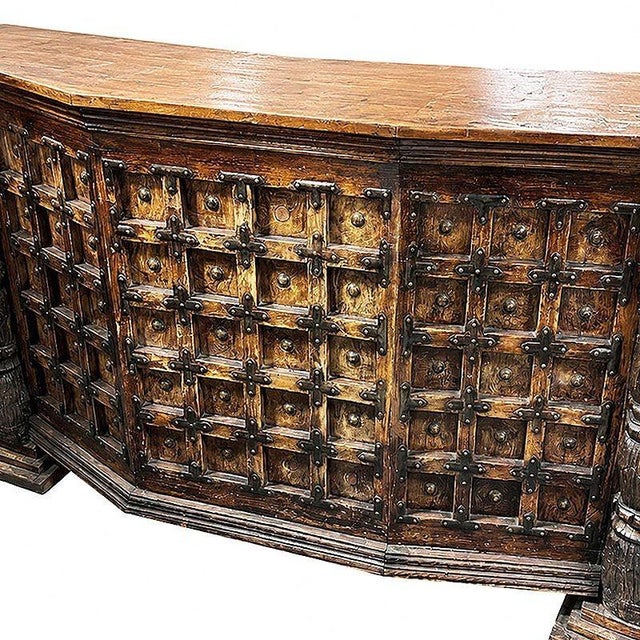A substantial Spanish Colonial hacienda style bar featuring a richly aged wood frame made from reclaimed wood accented by...