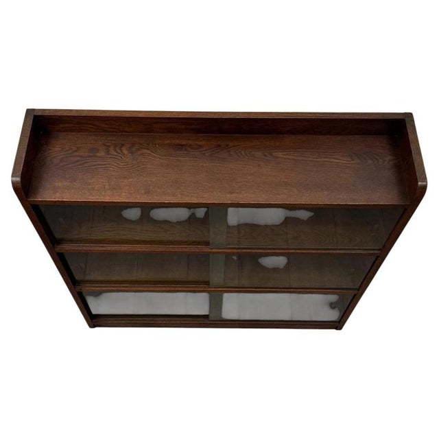 A substantial and highly practical 20th-century oak display cabinet, offering generous display capacity within an...