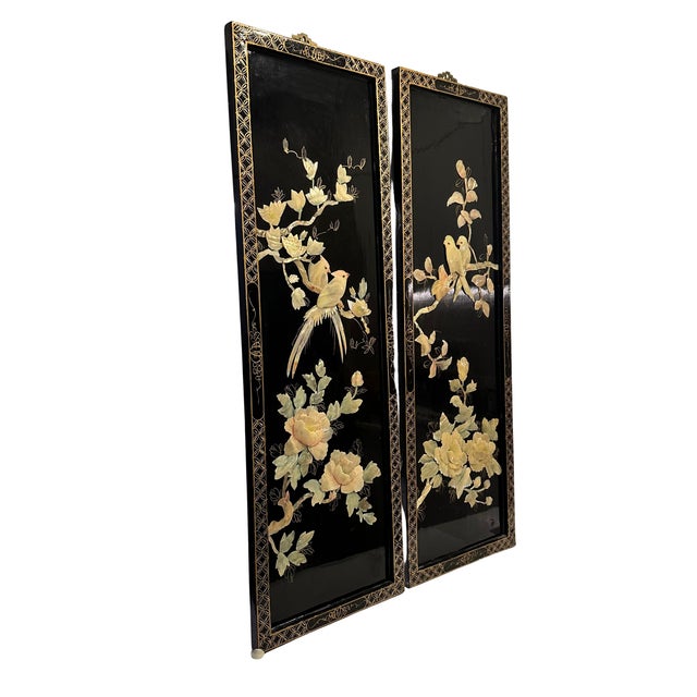 A striking pair of large decorative Chinese wall panels featuring intricate mother-of-pearl and shell inlay against a deep...