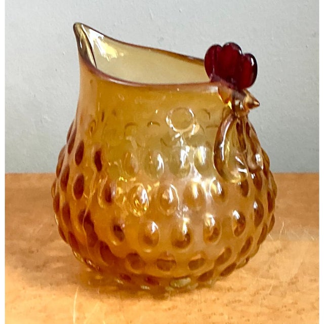 This vintage novelty pitcher is blown from amber glass and whimsically shaped as a plump, roosting hen, with the vessel's...