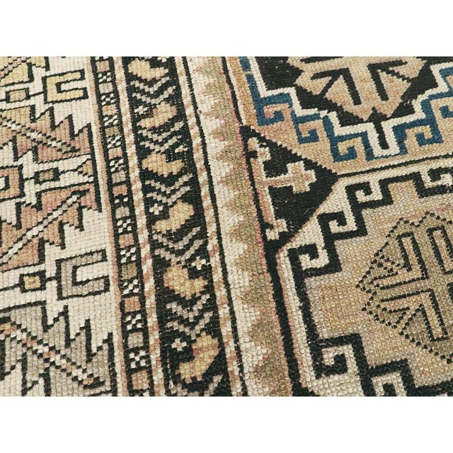 This early 20th century Caucasian Shirvan rug, measuring 2' 8" x 4' 10", presents a striking interplay of bold geometry...