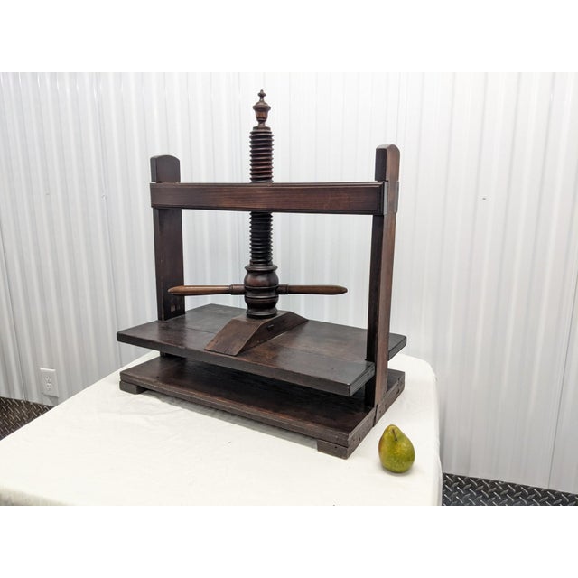 An early 20th century handcrafted oak book press with lovely patina, carved finial, straight columns, double-handled,...