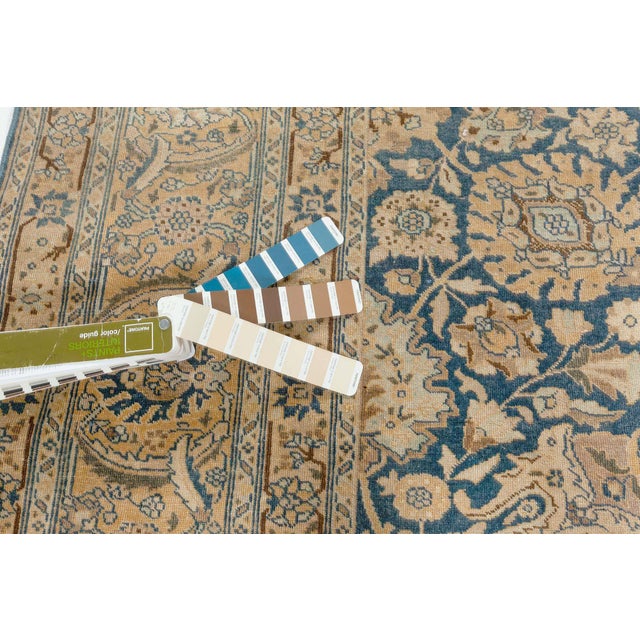 An early 20th century Persian Tabriz antique rug, the royal blue field with a flowering vinery, rosette and enlarged...