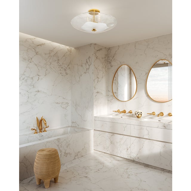 Glass takes center stage in this exquisite flush mount. The round shade is made of a thick piece of hand-blown piastra...