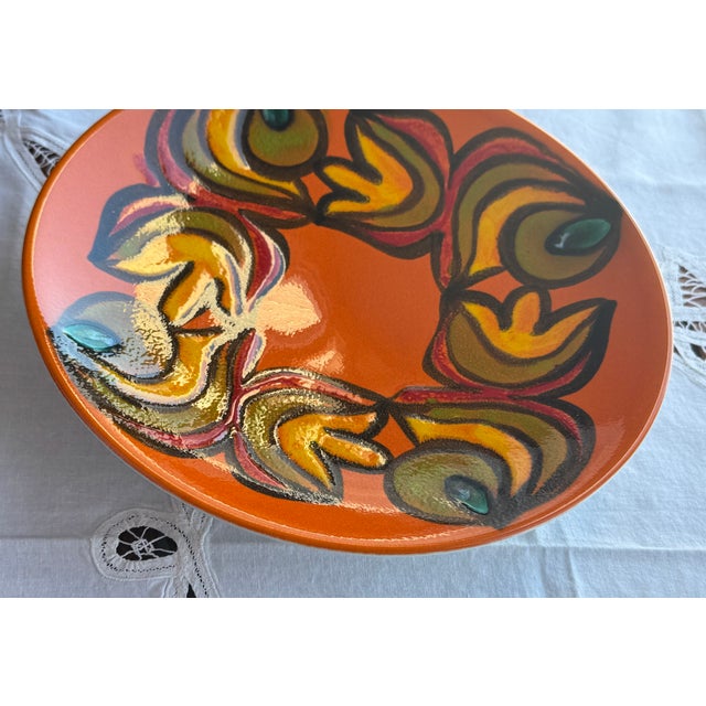 Hand-painted plate by Poole Pottery, England, dating to the mid-20th century. Abstract floral wreath design in vibrant...