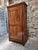 French bonnetière crafted from cherrywood, dating from the early 19th century. This tall, single-door cabinet features a...